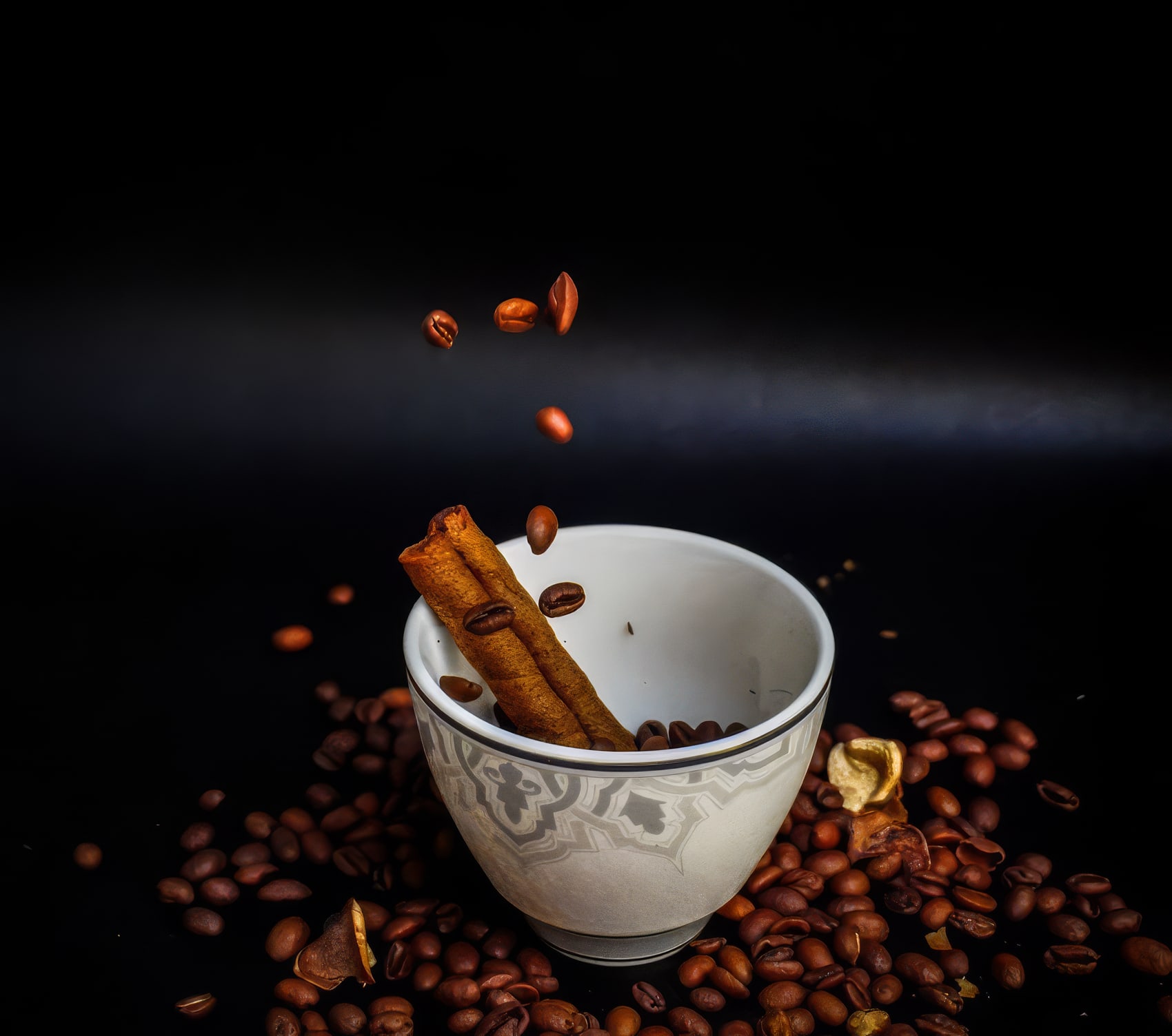 Student still-life photograph — coffee beans and cinnamon in a white bowl